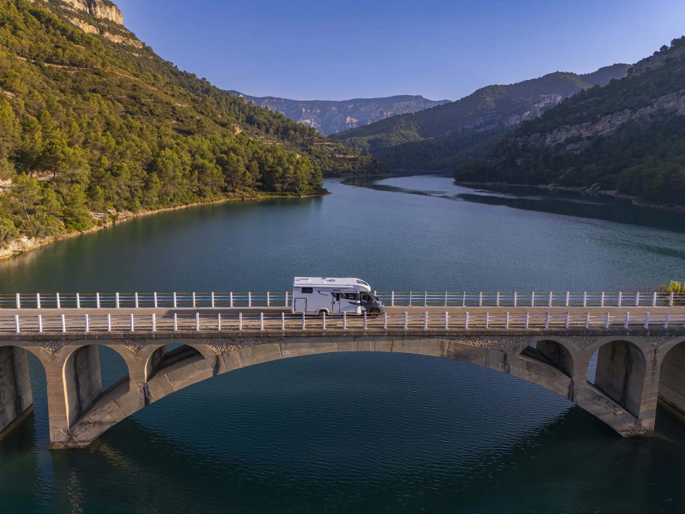 Autocaravana Benimar Kaleo cruzando un puente sobre un embalse
